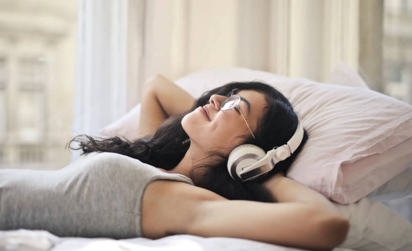 Junge Frau, die sich mit Musik vom Arbeitsstress entspannt