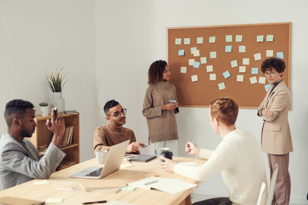 Eine Gruppe von Arbeitskollegen im Konferenzraum diskutieren über Change Management