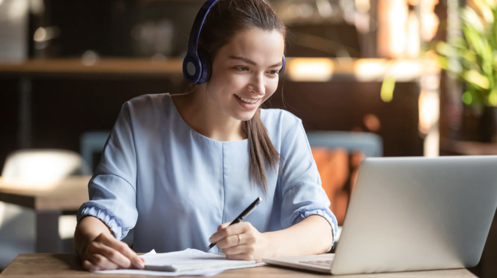 Eine junge Frau nimmt an einen Online Business Coaching mit ihrem Laptop teil